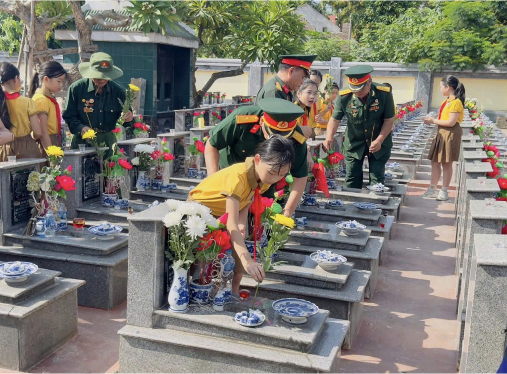 Giáo viên và học sinh nhà trường cùng các bác cựu chiến binh Xí nghiệp tập thể Thương binh Quang Minh viếng nghĩa trang Liệt sỹ